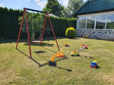 a playground with toys in the grass in a yard at La Reina Una in Bihać