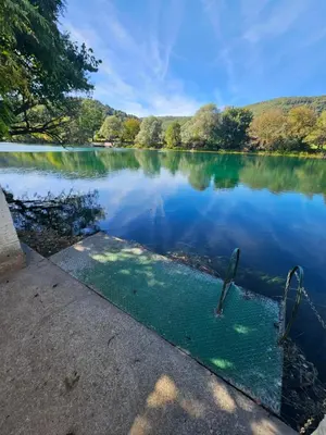 a view of a lake with trees in the background at La Reina Una in Bihać