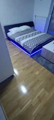 a bed in a room with a wooden floor at Apartman gavric in Doboj