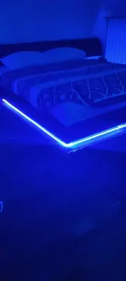 two beds in a dark room with a blue light at Apartman gavric in Doboj