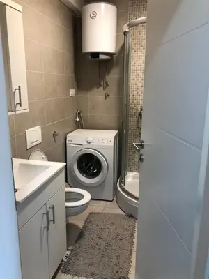 a bathroom with a washing machine and a washer at Apartman gavric in Doboj
