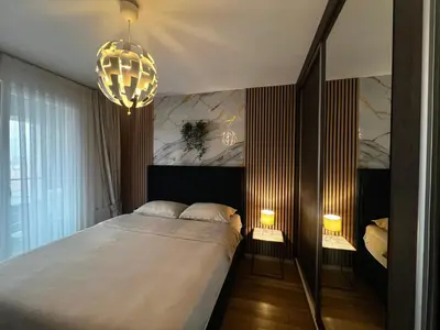 a bedroom with a bed and a chandelier at Emma Park Lake in Tuzla