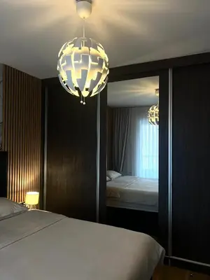 a bedroom with a bed and a mirror and a chandelier at Emma Park Lake in Tuzla