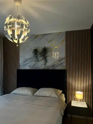 a bedroom with a bed and two chandeliers at Emma Park Lake in Tuzla