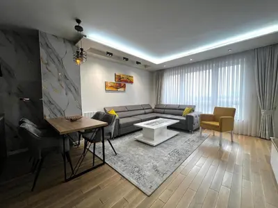 a living room with a couch and a table at Emma Park Lake in Tuzla
