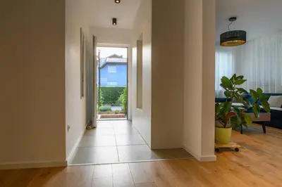 an empty hallway with a door leading to a living room at Beautiful modern apartment with large livingroom in Bihać