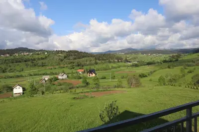 a view of a green field with houses on a hill at Lotus Villas in Travnik