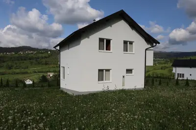 a white house in a field of flowers at Lotus Villas in Travnik