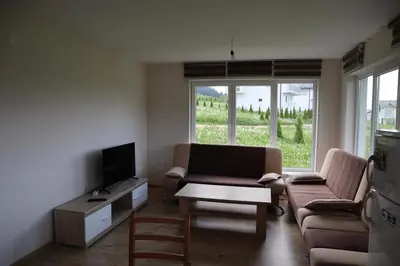 a living room with a couch and a tv and a table at Lotus Villas in Travnik