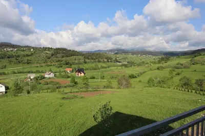 a view of a green field with houses on a hill at Lotus Villas in Travnik