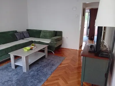 a living room with a green couch and a coffee table at Apartment Bedem Center in Bihać
