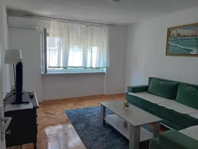a living room with a green couch and a table at Apartment Bedem Center in Bihać