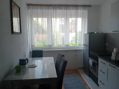 a kitchen with a table and a table and a window at Apartment Bedem Center in Bihać