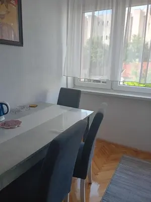 a dining room table with two chairs and a window at Apartment Bedem Center in Bihać