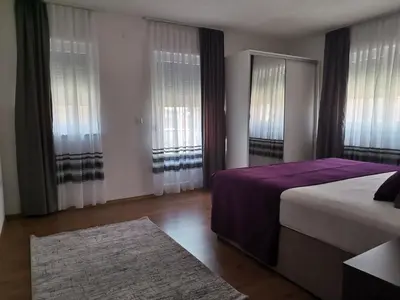 a bedroom with a bed with purple sheets and windows at Apartman Sali in Bihać