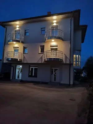 a large white building with two balconies on it at Apartman Sali in Bihać