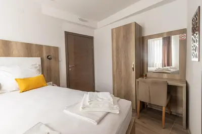 a bedroom with a bed and a chair and a mirror at Verdi Rooms in Visoko