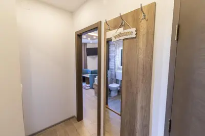a bathroom with a toilet and a door with a mirror at Verdi Rooms in Visoko