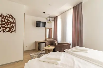 a hotel room with two beds and a chair at Verdi Rooms in Visoko