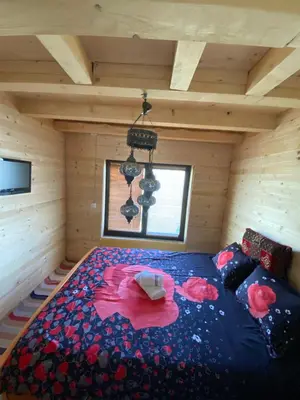 a bedroom with a bed in a wooden room at Prokoško jezero Zlatna koliba in Fojnica