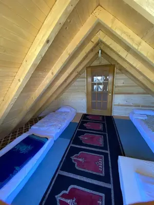 a room with two beds in a attic at Prokoško jezero Zlatna koliba in Fojnica