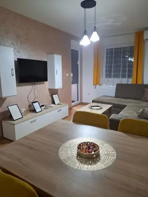 a living room with a table with a bowl of fruit on it at Apartman Bulevar in Doboj