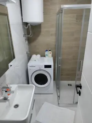 a bathroom with a washing machine and a sink at Apartman Gavric in Doboj
