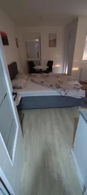 a bedroom with a bed and a table in it at Apartman Gavric in Doboj