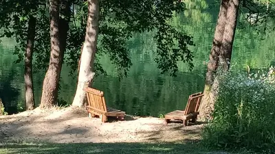 two wooden benches sitting next to a body of water at Holiday home Una - H in Bosanska Krupa