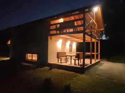 a house at night with a table and chairs at Holiday home Una - H in Bosanska Krupa