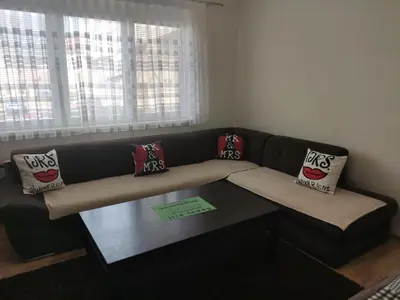 a couch in a living room with pillows on it at Apartmani Sarah Tuzla in Tuzla