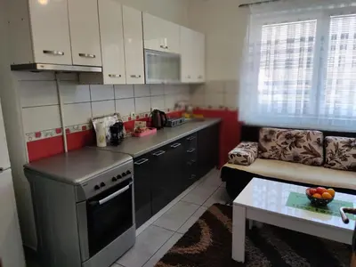 a kitchen with a stove and a couch and a table at Apartmani Sarah Tuzla in Tuzla