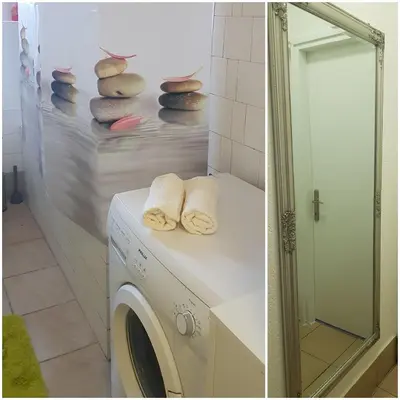 a bathroom with a washing machine and a mirror at Apartmani Sarah Tuzla in Tuzla