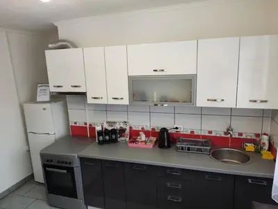 a kitchen with white cabinets and a sink at Apartmani Sarah Tuzla in Tuzla