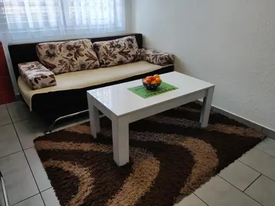 a living room with a white coffee table and a couch at Apartmani Sarah Tuzla in Tuzla