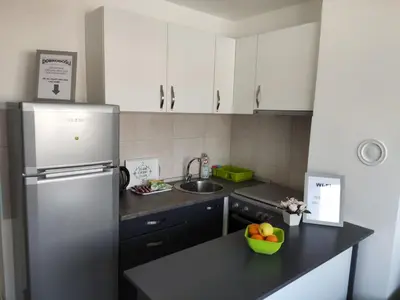 a kitchen with a refrigerator and a bowl of fruit on a counter at Apartmani Sarah 2 Tuzla in Tuzla