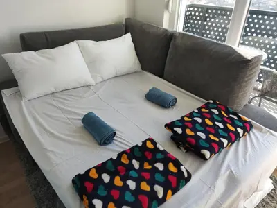 a couch with two pillows on top of it at Apartmani Sarah 2 Tuzla in Tuzla
