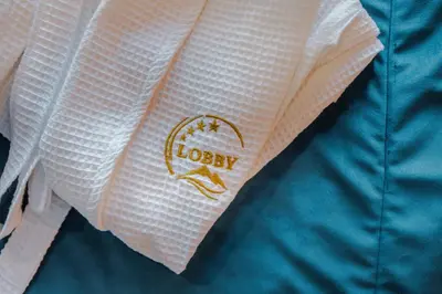 a close up of a white shirt with a logo on it at HOTEL LOBBY in Bihać