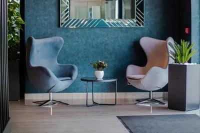 two chairs and a table in a room with a mirror at HOTEL LOBBY in Bihać