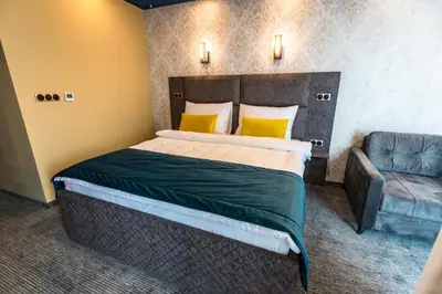 a bedroom with a large bed and a couch at HOTEL LOBBY in Bihać