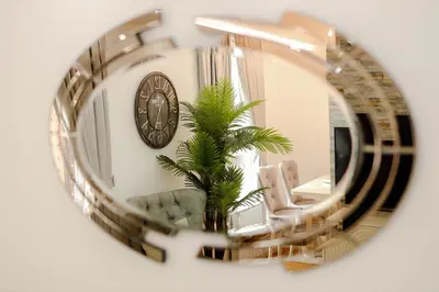a mirror reflection of a living room with a clock at Fontana apartmani FREE parking in Tuzla