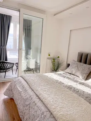 a white bedroom with a large bed and a balcony at Fontana apartmani FREE parking in Tuzla