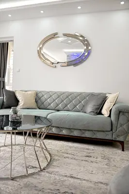 a living room with a couch and a large mirror at Fontana apartmani FREE parking in Tuzla