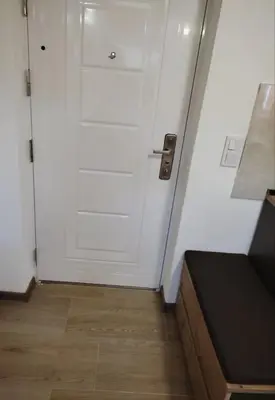 a white door in a room with a wooden floor at Dream Home Studio Apartments in Tuzla