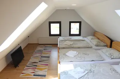 a attic bedroom with three beds and a tv at Vila Ana in Travnik