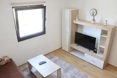 a living room with a flat screen tv and a table at Vila Ana in Travnik