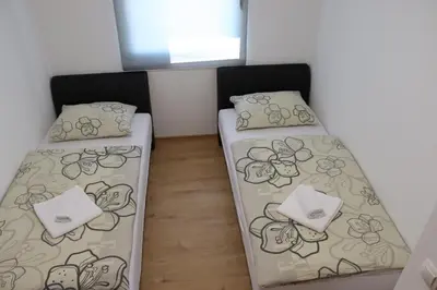 two beds in a small room with a window at Vila Ana in Travnik