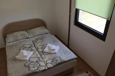 a small bed with two pillows and a window at Vila Ana in Travnik