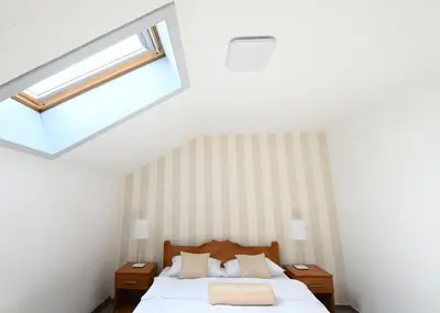 a bedroom with a bed and a skylight at Sobe - Rooms Drvorez in Banja Luka