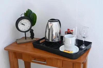 a tray with a coffee maker and a clock on a table at Sobe - Rooms Drvorez in Banja Luka